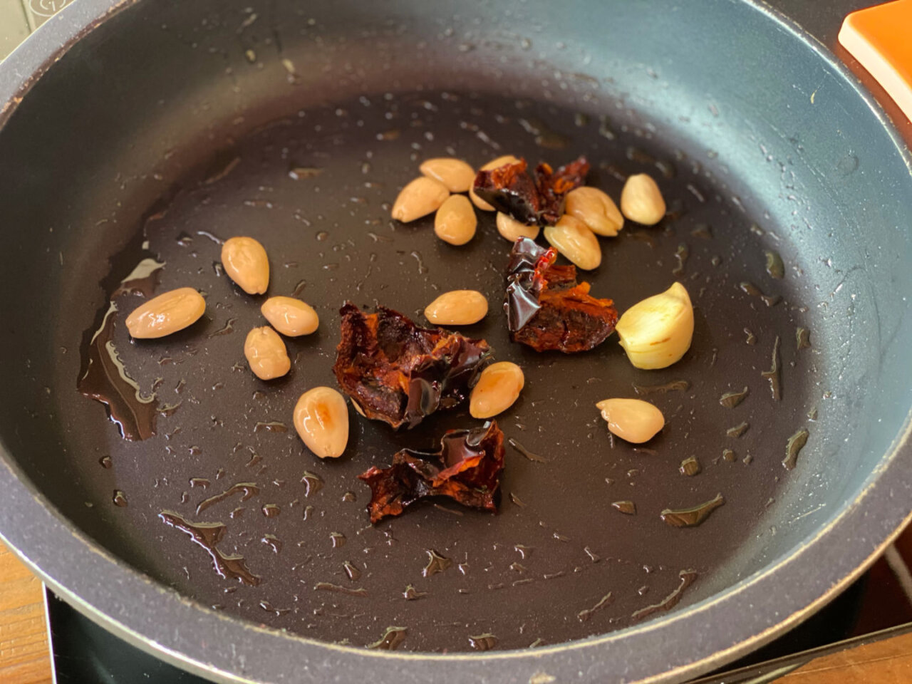 Doramos los ajos cortados , las almendras y los pimientos choriceros