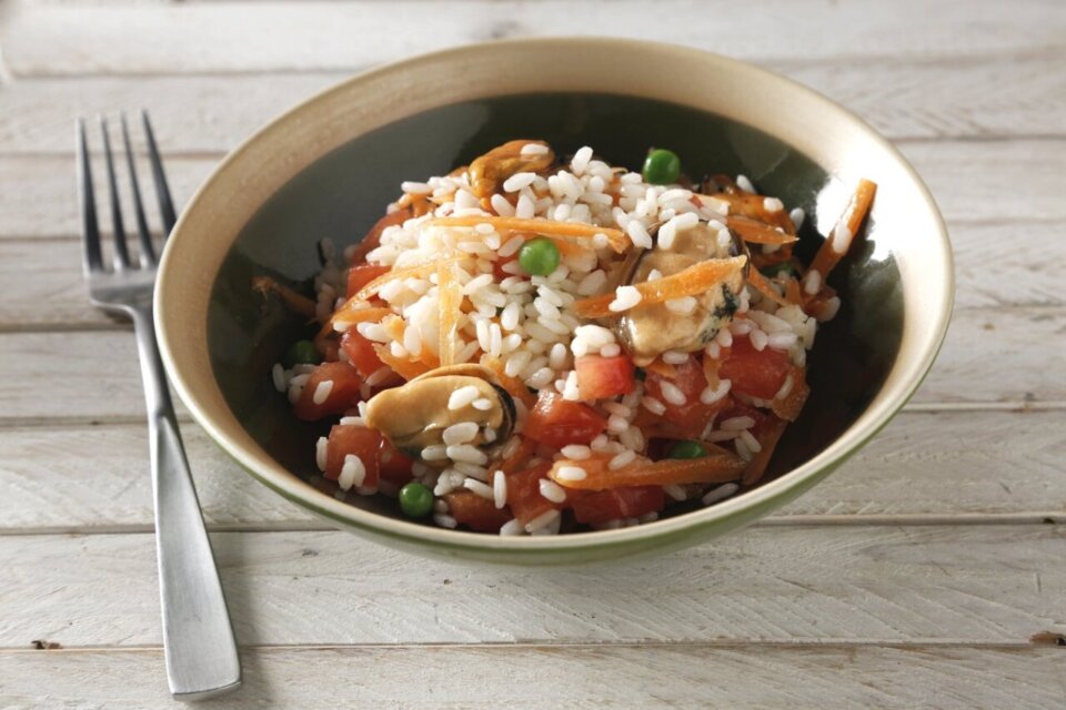 Arroz con tomate, mejillones, guisantes y zanahoria