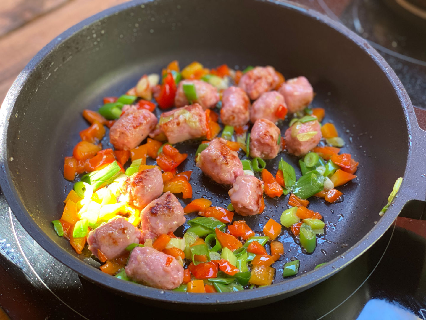 cocinamos las salchichas con la verdura troceada en el wok