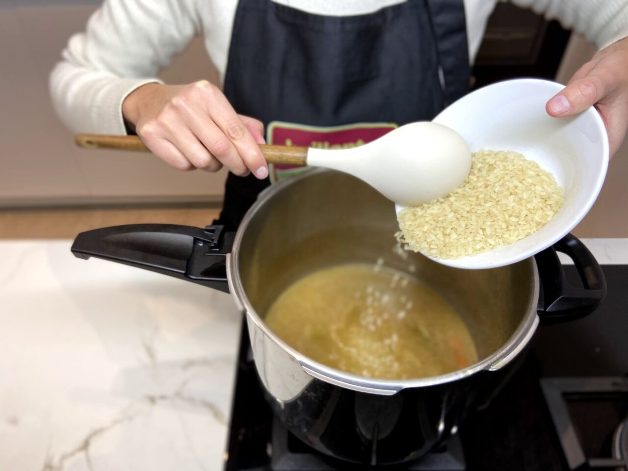 se añade el arroz a la olla junto con la carne