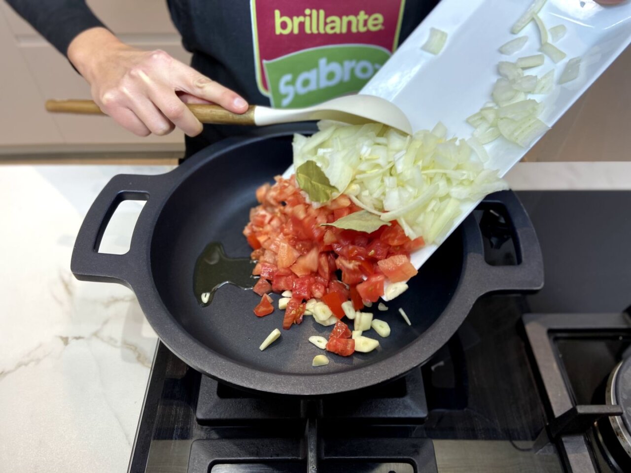 sofreír el tomate, la cabeza de ajo y el laurel