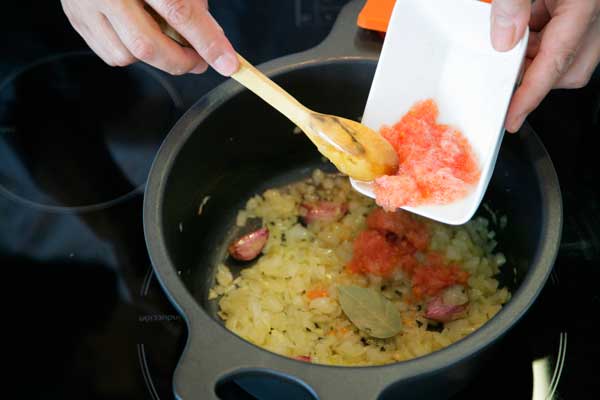 Freímos la mezcla de cebolla, tomate y laurel junto al aceite y los ajos.