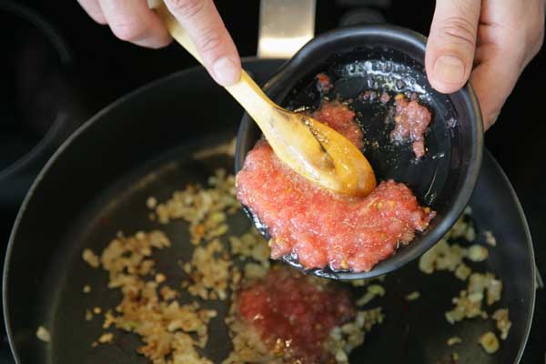 Añadimos el tomate rallado a la sartén y sofreímos a fuego lento