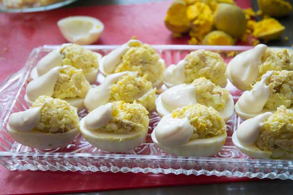 Formamos bolitas de la mezcla anterior y vamos rellenando los huevos y los decoramos con un poco de mayonesa