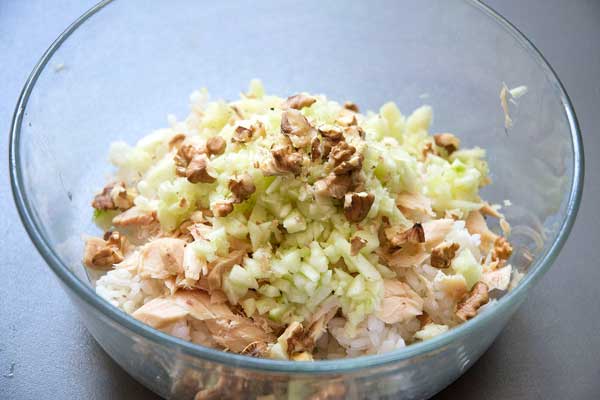 Añadimos el bonito del norte en conserva desmigado, la manzana y  las nueces picadas en el recipiente