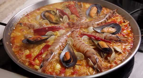 Poner las almejas, los mejillones, los langostinos y las tiras de pimiento asado