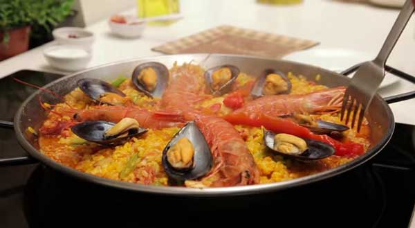 Bajamos el fuego y añadimos los mejillones, los langostinos y el pimiento asado