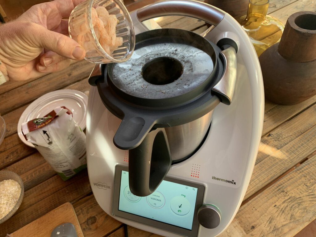 Limpiamos el vaso de la Thermomix e incorporamos en su interior los cuerpos de las gambas, la cebolla y el tomate natural triturado