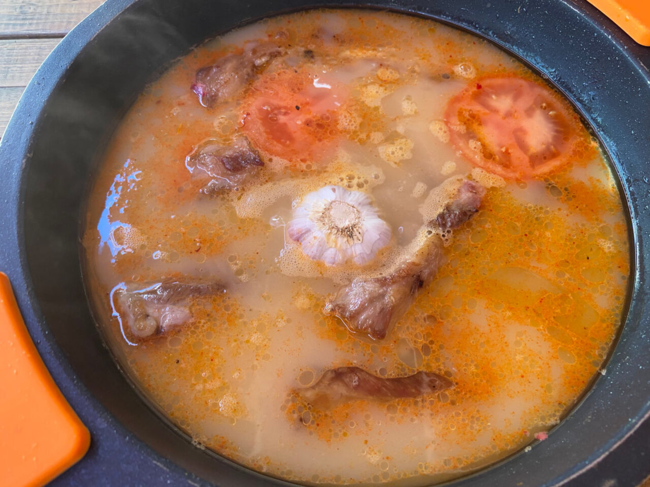 Añadimos los tomates, la cabeza de ajos, el caldo hirviendo y el azafrán