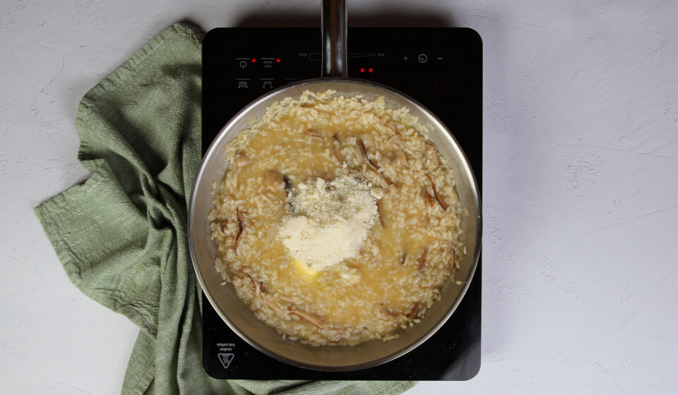Reincorporar setas, echar queso y mantequilla en risotto de setas
