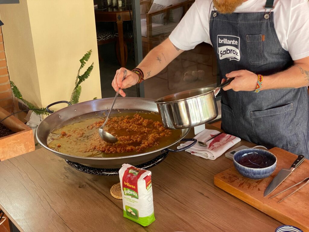 Echamos el caldo y extendemos bien el arroz por toda la paella