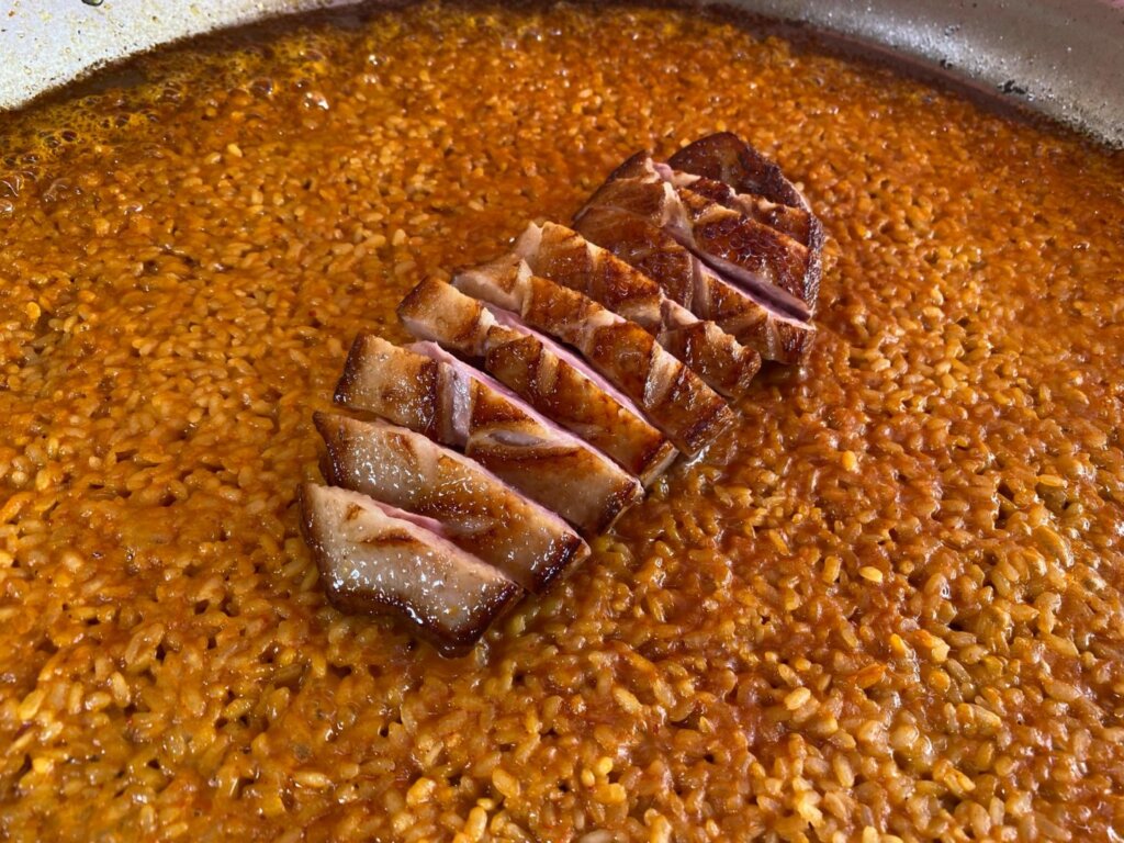 Cortamos en trozos el pato y lo ponemos encima del arroz y finalmente colocamos las frambuesas.