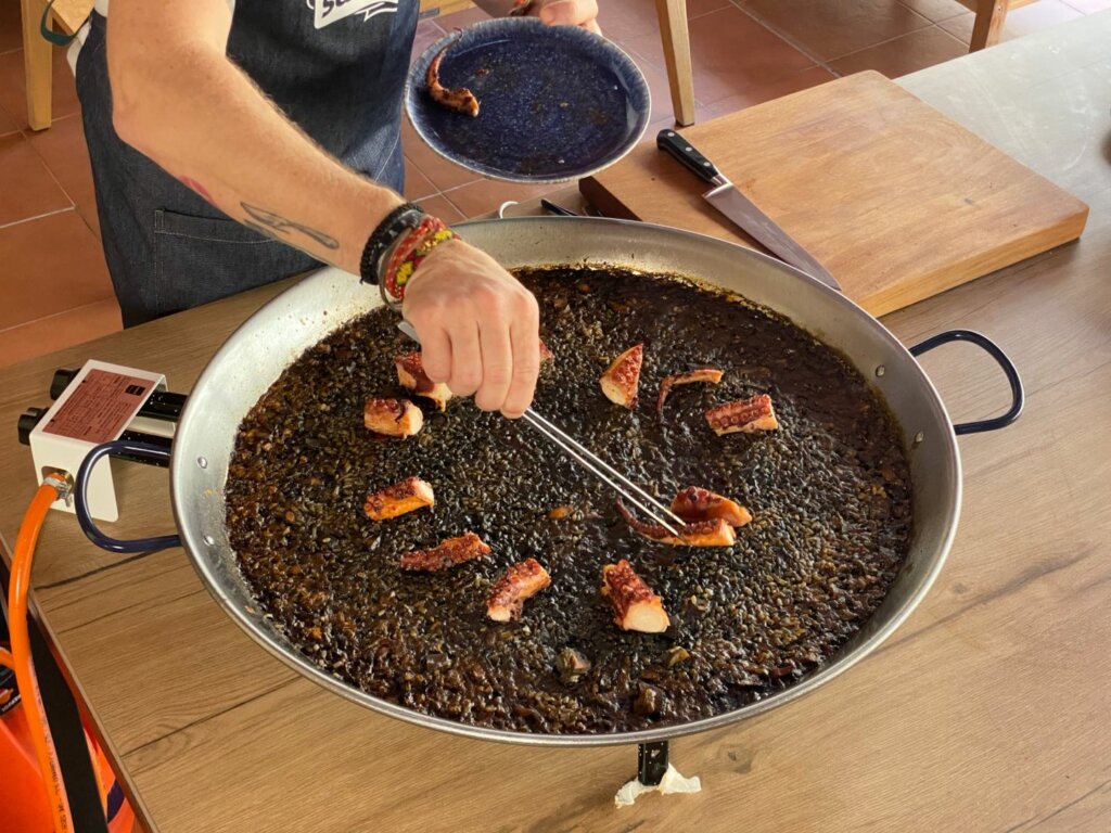 chef agregando pulpos cortados a la receta