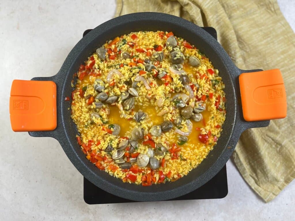 Receta arroz con gambas paso 3 sofreímos el pimiento rojo junto al tomate triturado. Añadimos el arroz e incorporamos el caldo de cocción