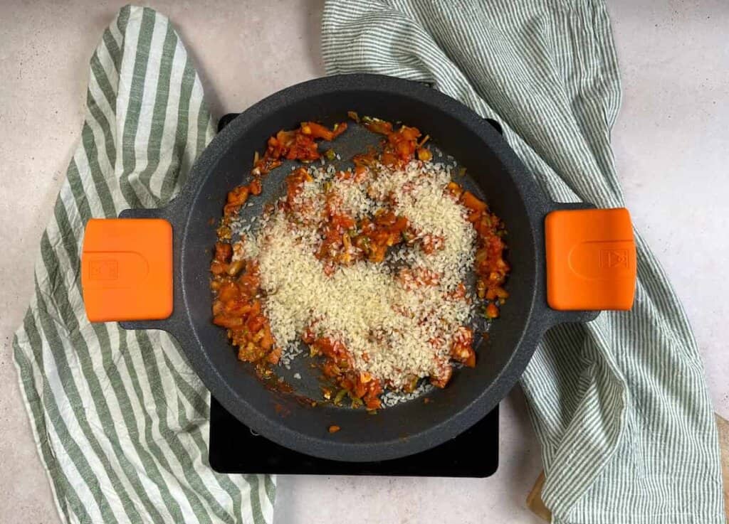 Receta arroz con habichuelas paso 2 Añade el arroz a la sartén. Remueve y añade el boniato y las habas cocidas