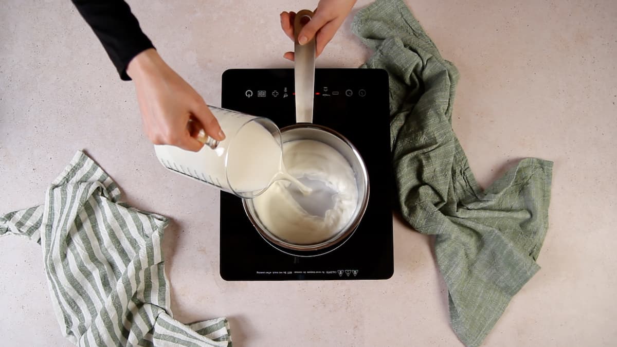 Receta arroz con leche cremoso paso 1 calienta leche entera y nata junto a una rama de canela. Después, incorpora ralladura de limón