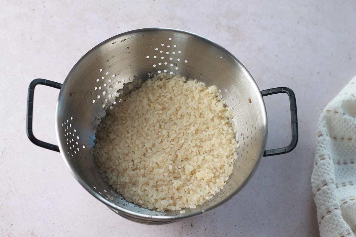 Receta arroz con leche paso 1 lava cuidadosamente el arroz. A continuación, cuécelo en agua hirviendo durante 5 minutos.