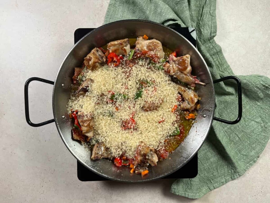 Receta paella de conejo. Paso 3: Incorporar el arroz