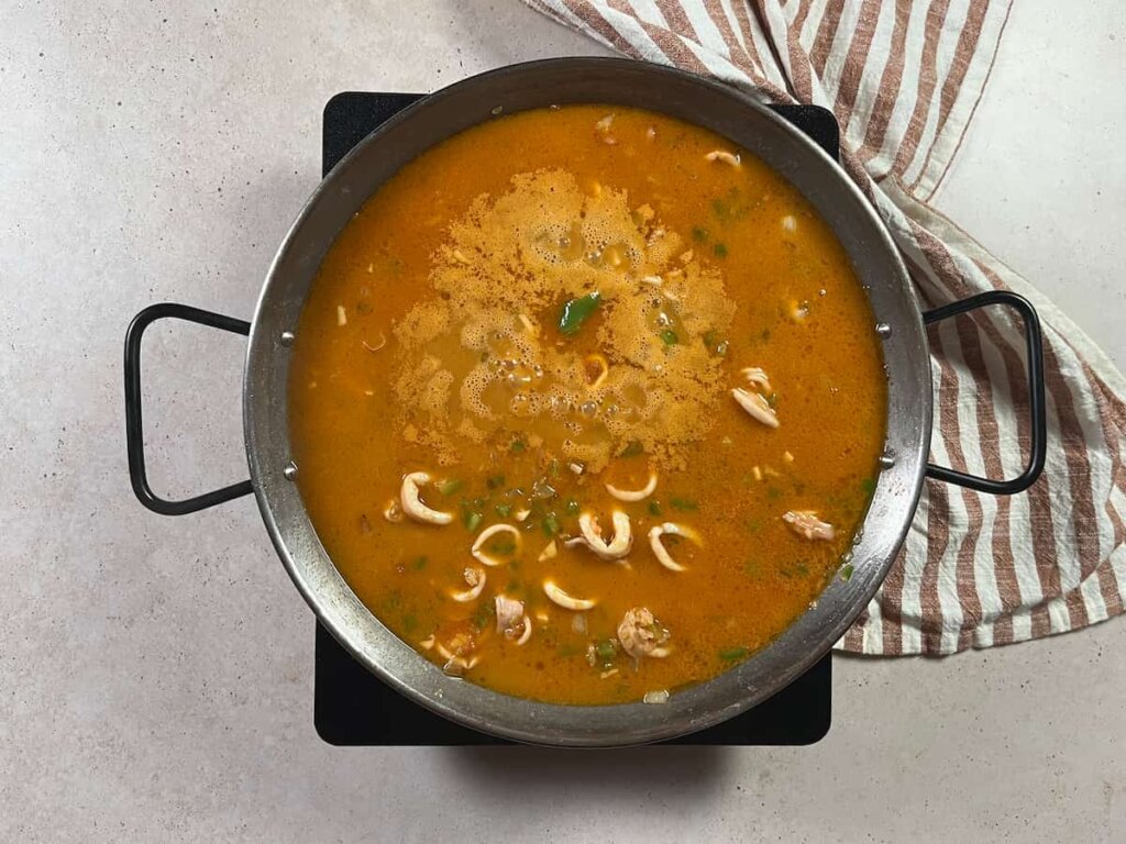 Arroz con calamares en su tinta. Paso 5: agregar el caldo