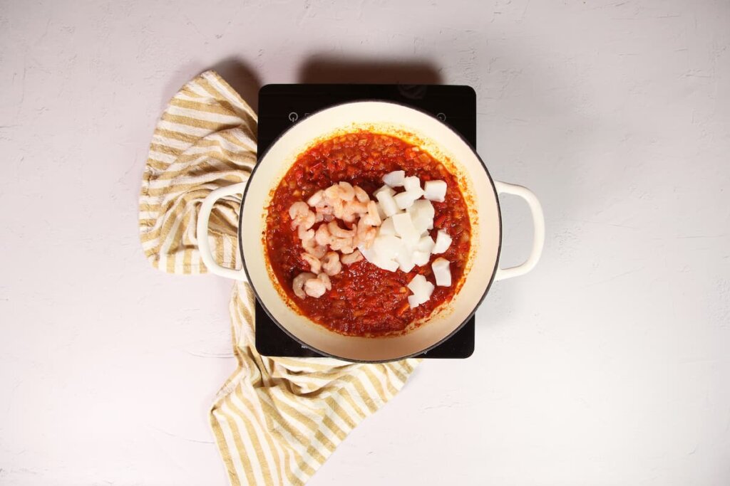 Incorporación de sepia y gambas: el corazón del plato