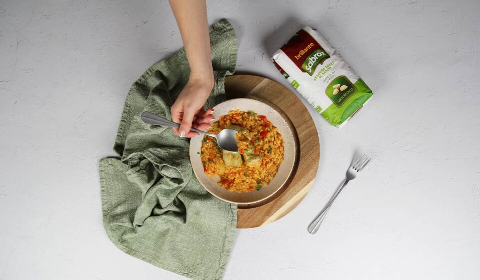 Presentación de arroz meloso con alcachofas