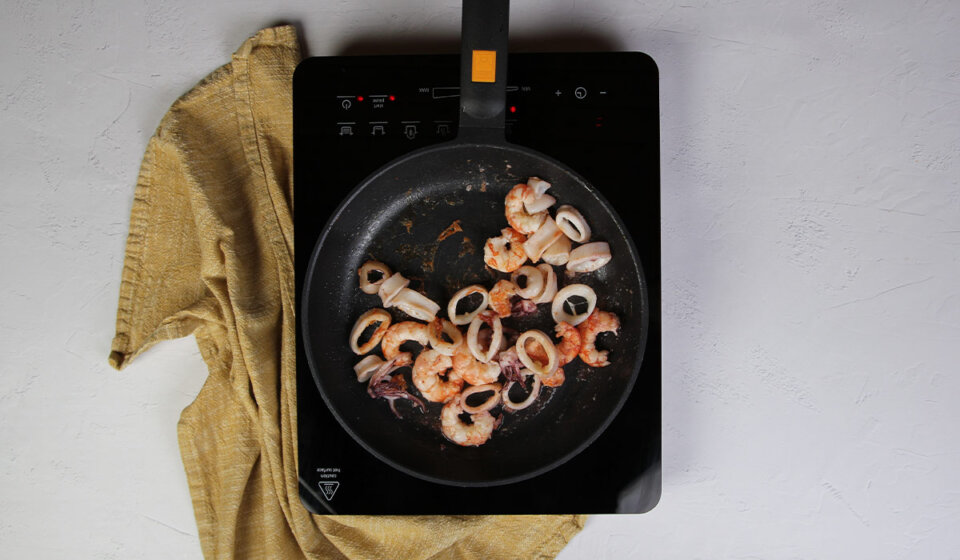 Sofreír calamares y gambas en arroz a la valenciana