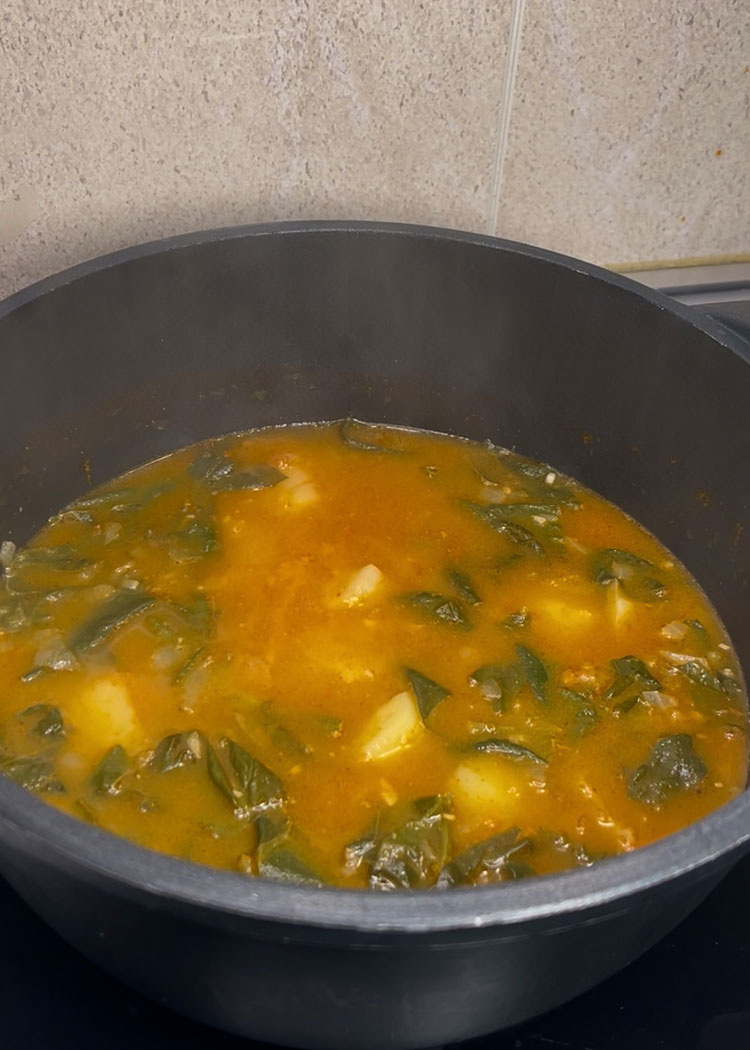 Añadir caldo y arroz a arroz con acelgas y alubias