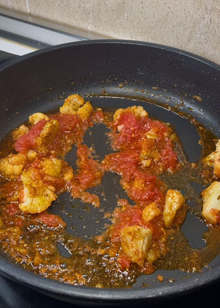 Añadir pimentón y tomate a arroz con bacalao y coliflor