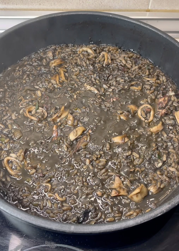 Verter fumet y reintegrar chipirones a Arroz negro con chipirones