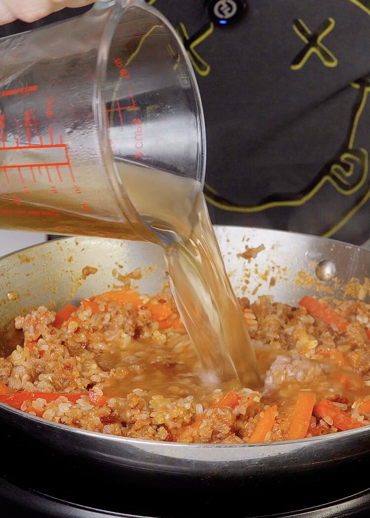 Incorporar caldo para arroz con carne picada