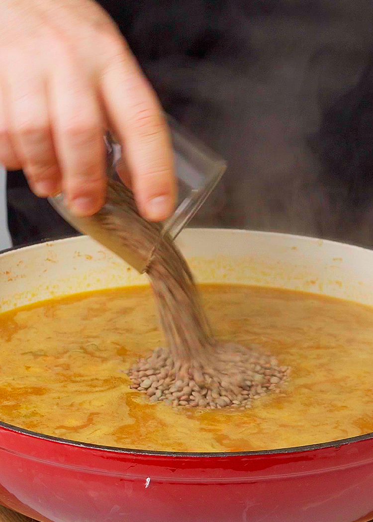 Echar caldo y lentejas para arroz con lentejas